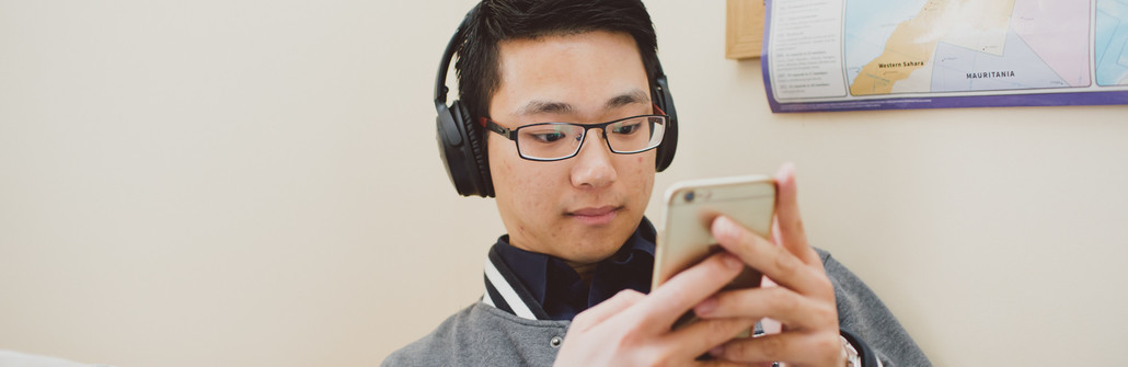 Man listening to phone through headphones